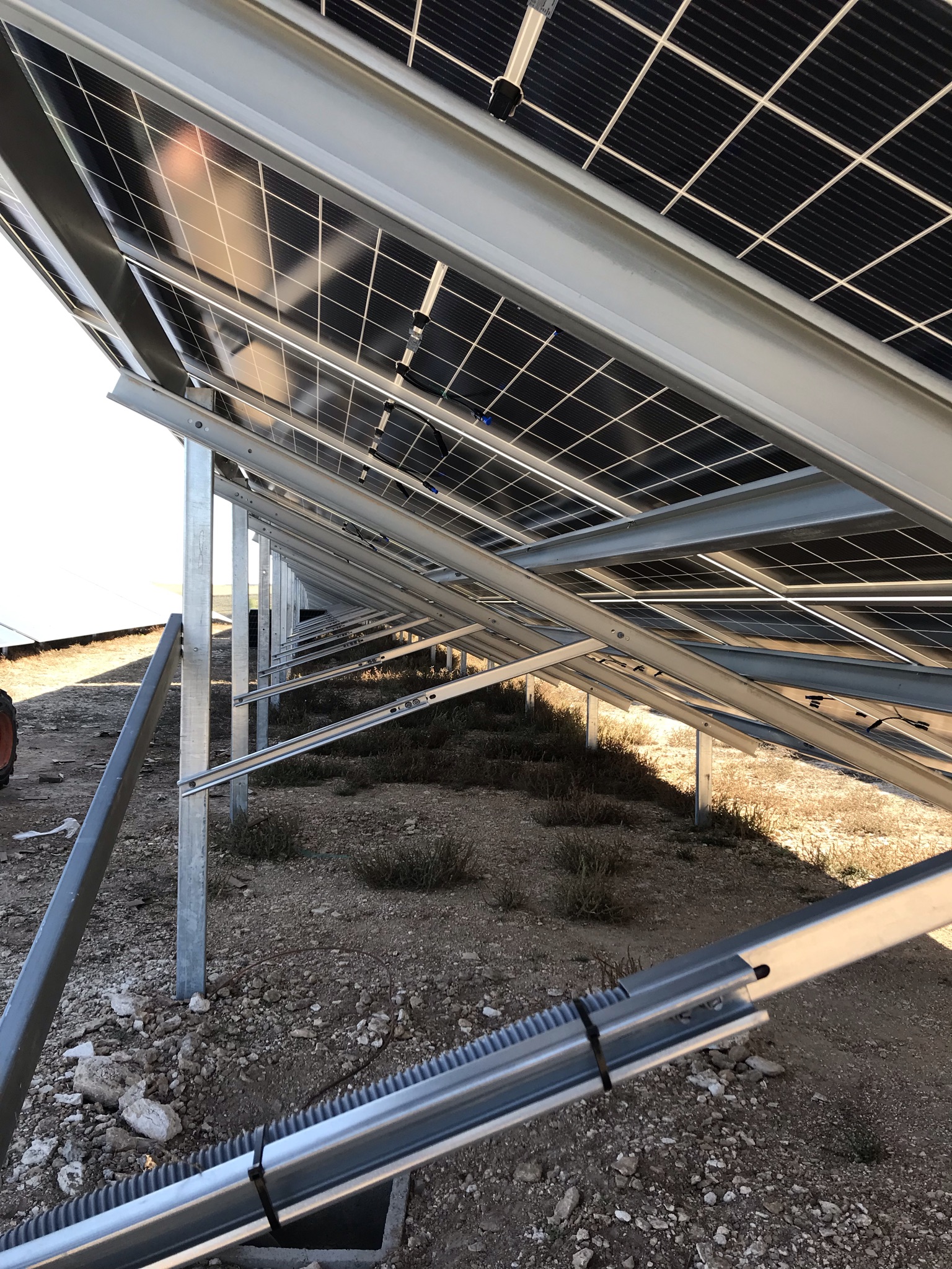 Estructura metálica y paneles solares fotovoltaicos vistos desde abajo en un parque solar