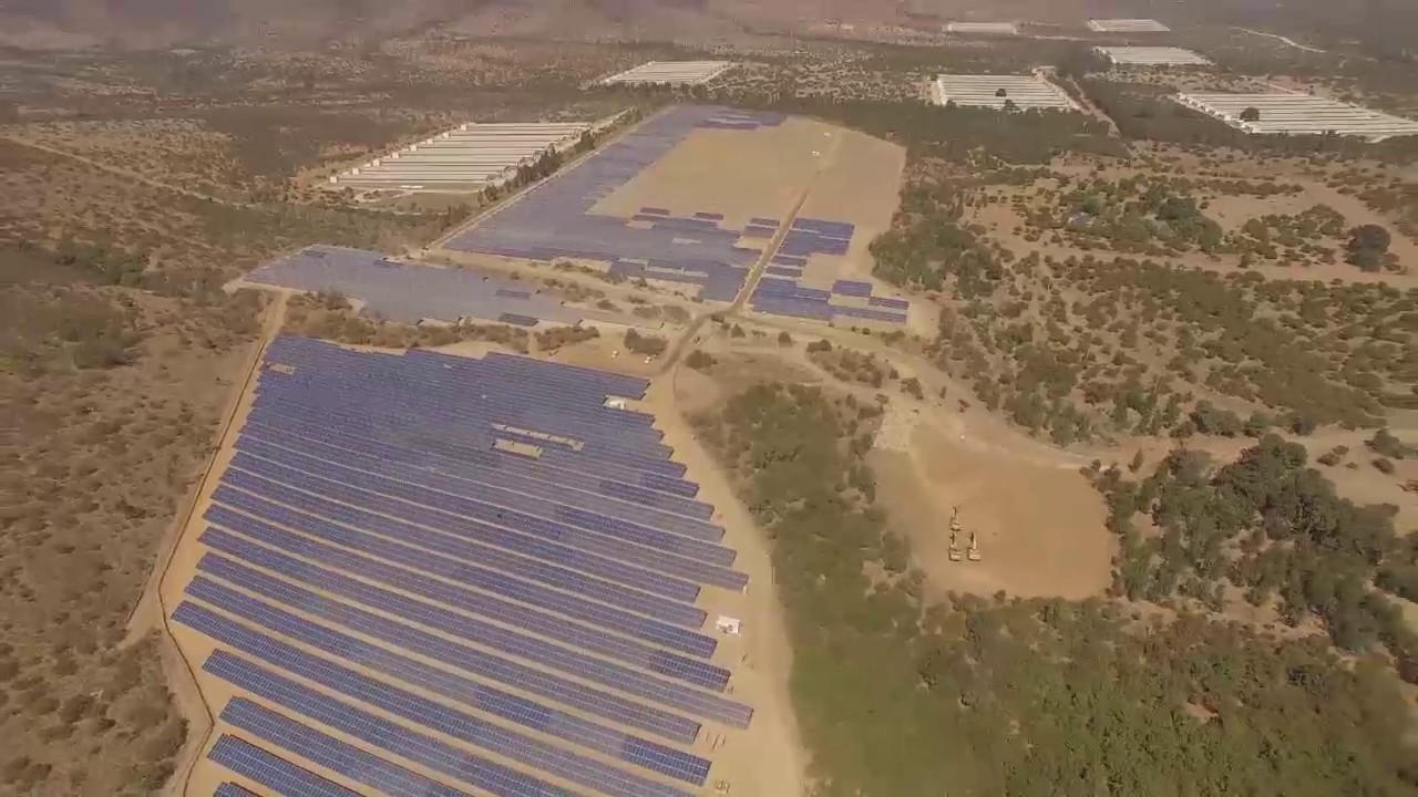 Vista aérea de una planta solar fotovoltaica a gran escala con miles de paneles solares instalados en el desierto