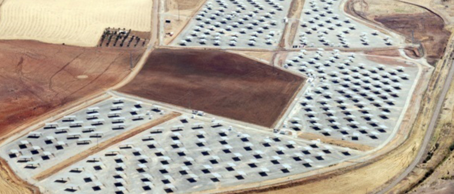 Vista aérea de una planta solar fotovoltaica en construcción con múltiples estructuras de soporte para paneles solares