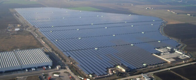 Vista aérea de planta solar fotovoltaica a gran escala con miles de paneles solares