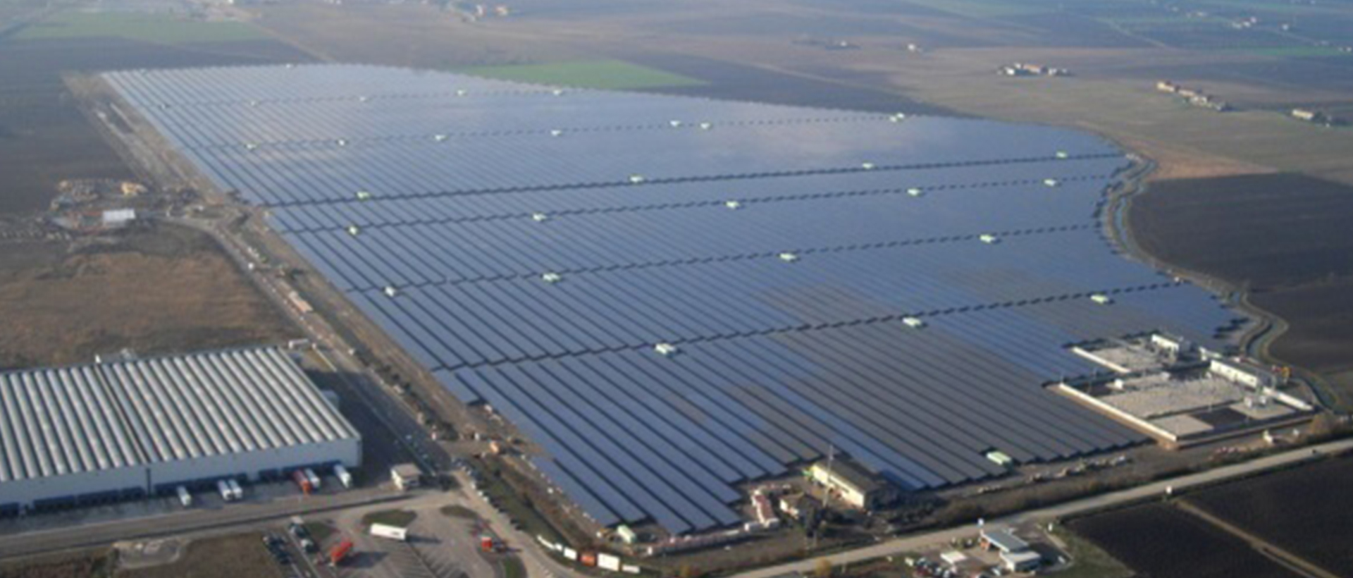 Vista aérea de planta solar fotovoltaica a gran escala con miles de paneles solares