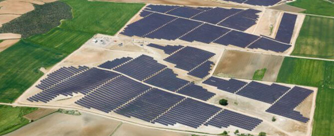 Vista aérea de una planta solar fotovoltaica con seguidores a un eje en terreno agrícola